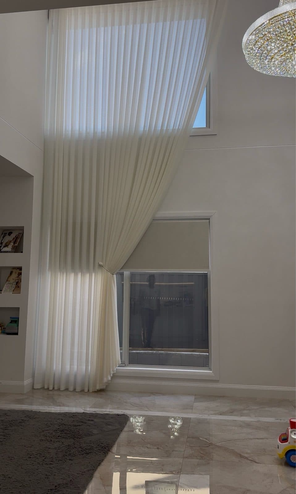 Double-height S-fold sheer curtain with a tieback in a Melbourne home